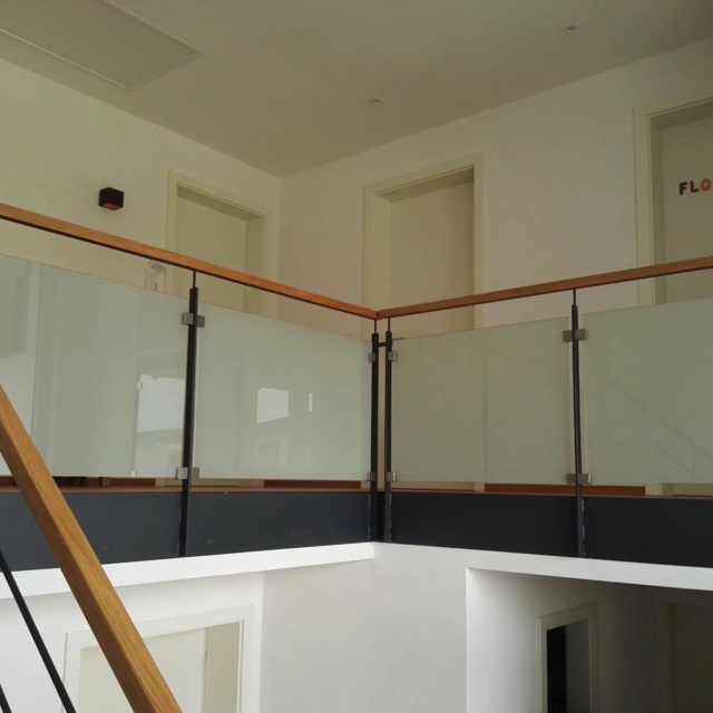 Galeriegeländer aus Stahl mit Holzhandlauf und Glasfüllung